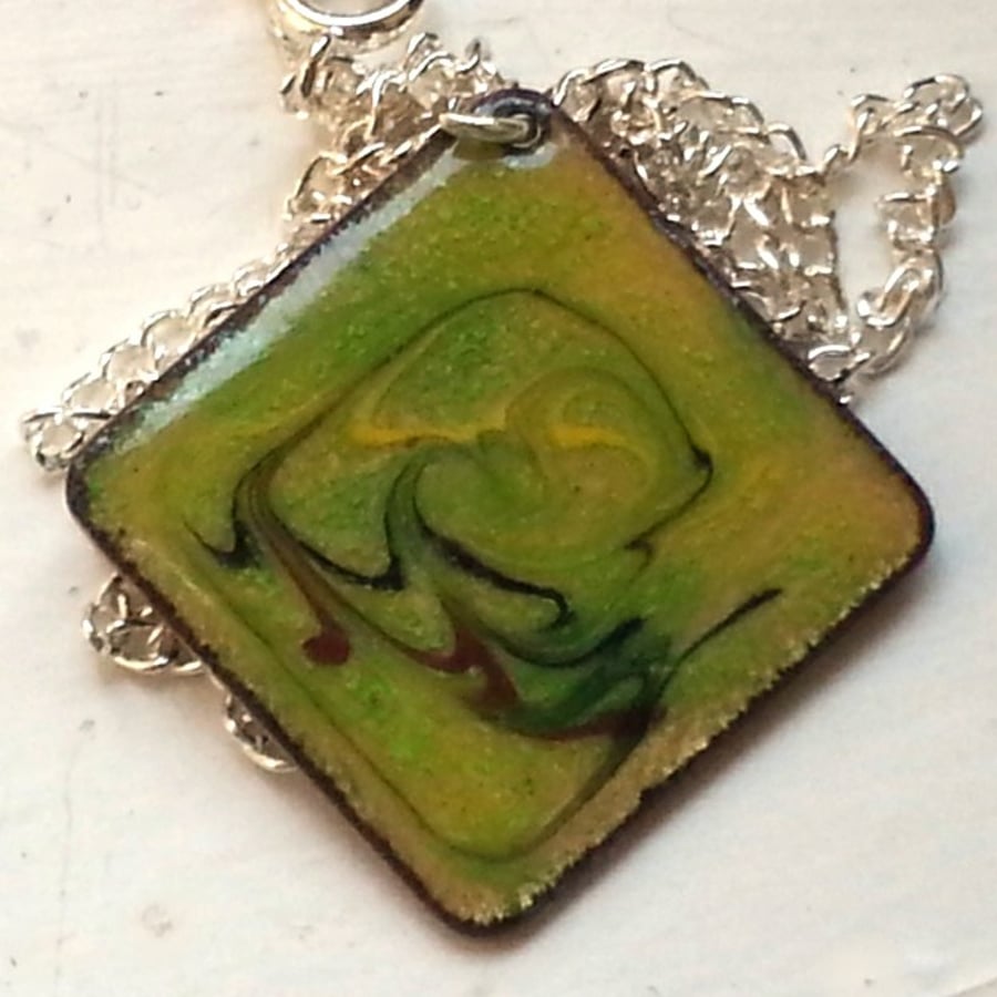 red-brown, black and yellow scrolled on green over clear -  square pendant 