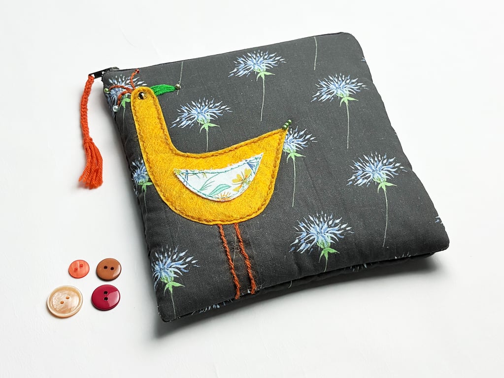 Black thistle print make-up bag with appliquéd orange bird