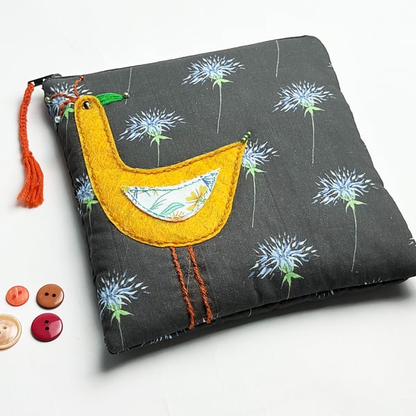 Black thistle print make-up bag with appliquéd orange bird