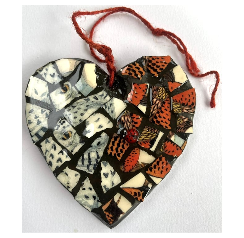 A heart shaped mosaic pendant with a snowy and barn owl theme.