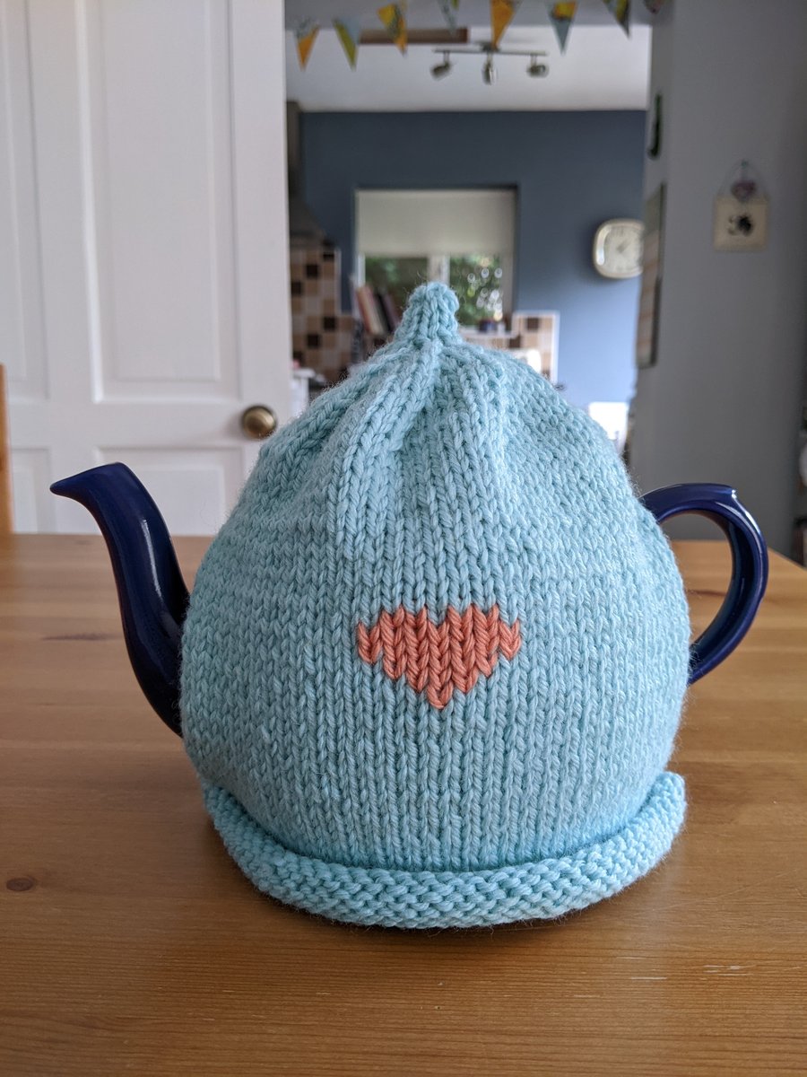 Blue knitted tea cosy with pink heart