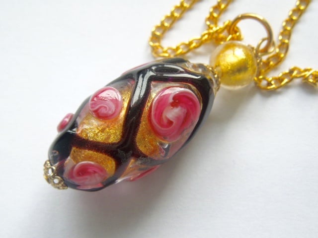 Murano glass black and gold rose pendant with gold chain.