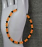 UV Reactive Orange Glass Bead and Black Glass Bicone Elastic Bracelet