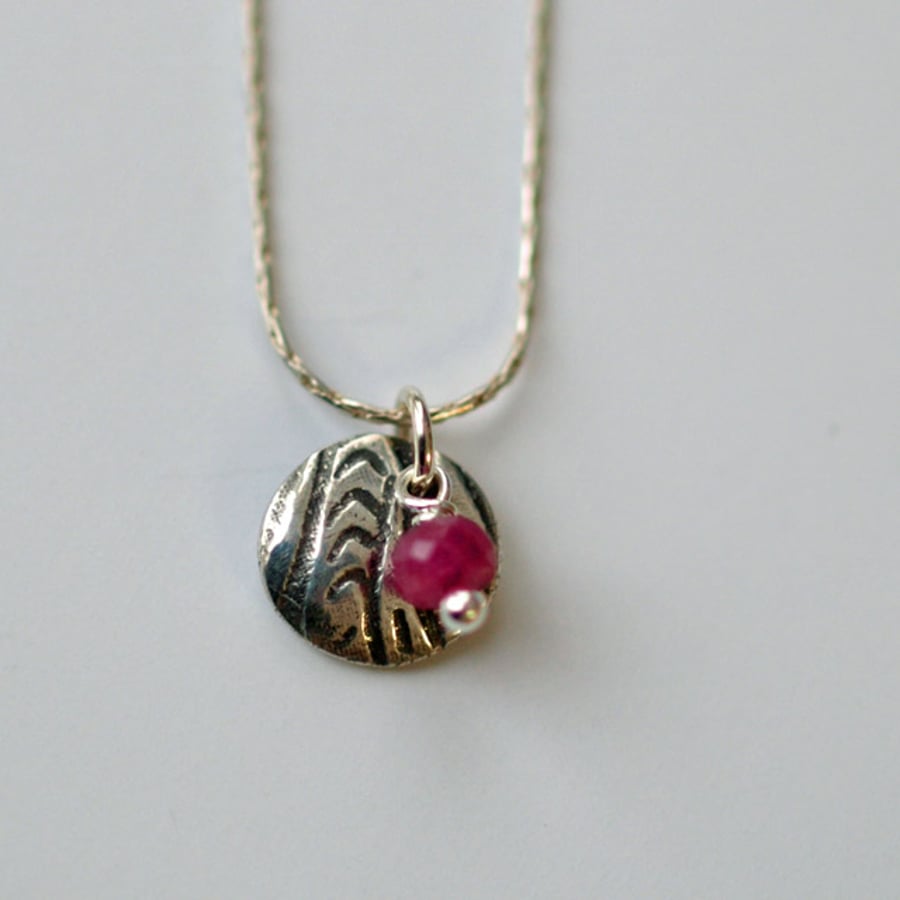 Little patterned disc and ruby pendant