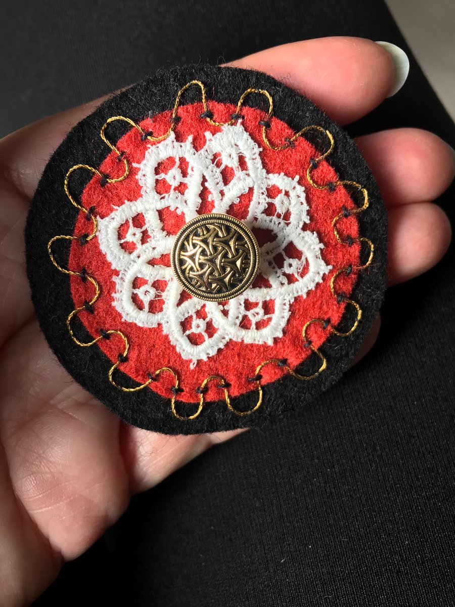 Hand embroidered corsage in black, cinnamon and gold.