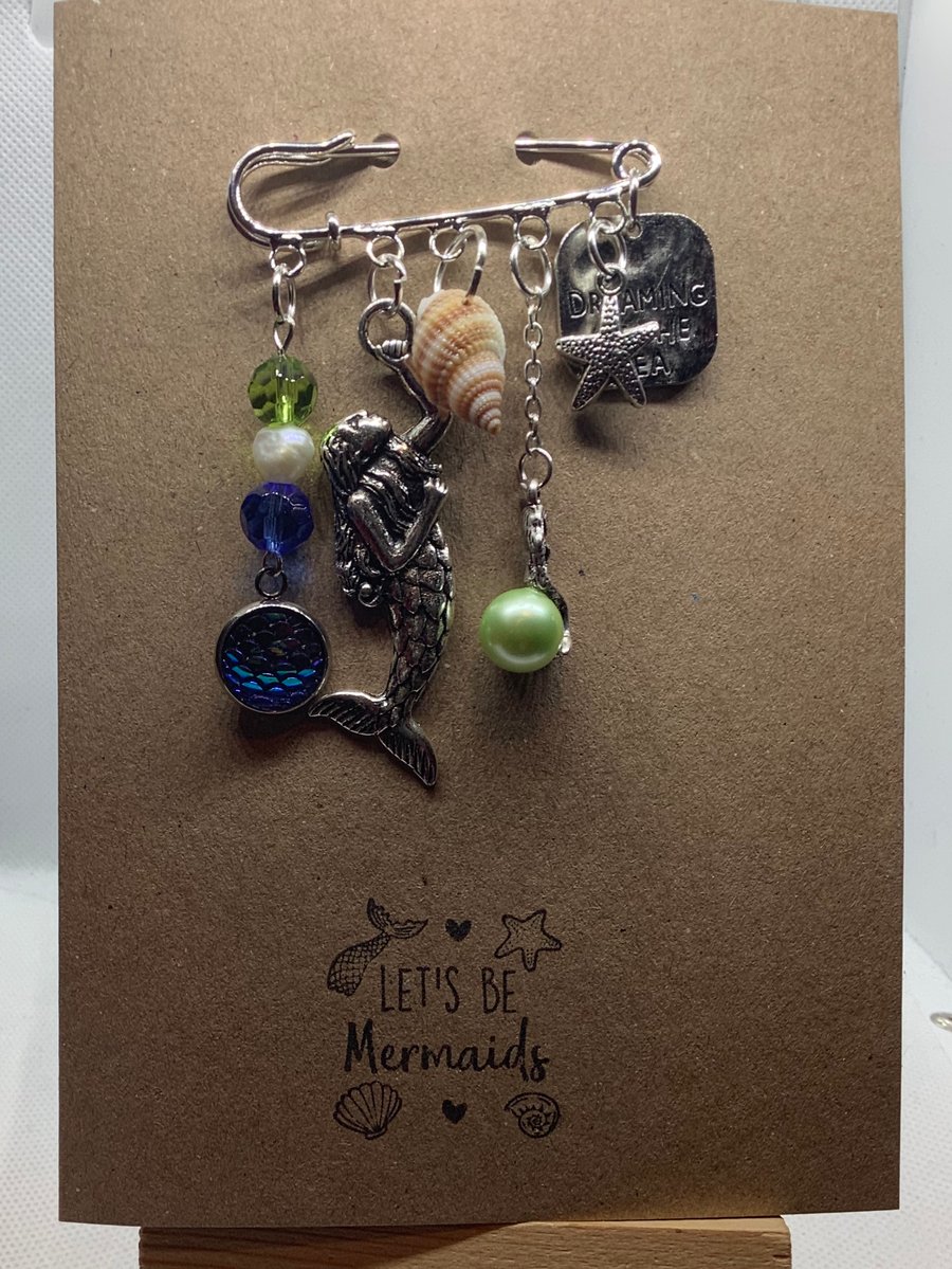 Handmade kilt pin mermaid themed brooch, attached to kraft greetings card.