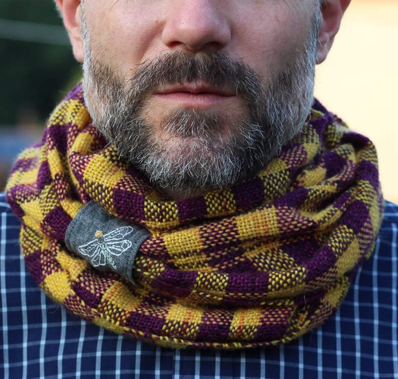 Hand woven unisex check cowl in yellow and purple with an embroidered dragonfly
