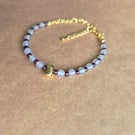 Owl grey and deep red, strength stone, gold bracelet.