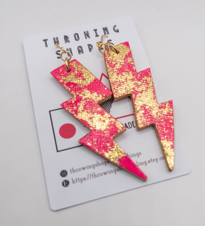 Handmade Neon pink lightening bolt earrings made from leather. Gold leaf details