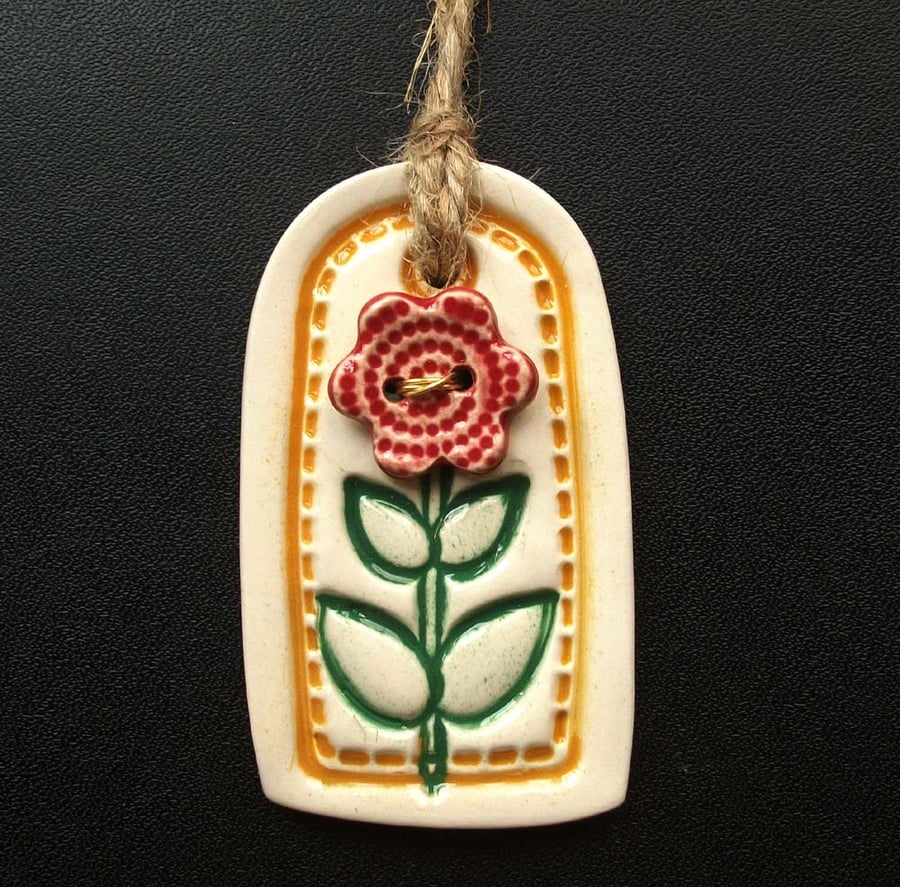 Small yellow ceramic tag decoration with flower button
