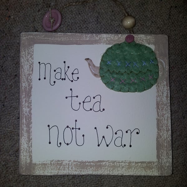 'Make Tea not War' wooden wall plaque.