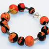 Polymer clay bracelet in black, orange, red and yellow