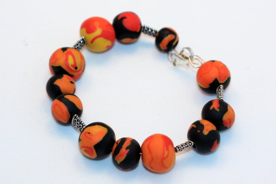Polymer clay bracelet in black, orange, red and yellow