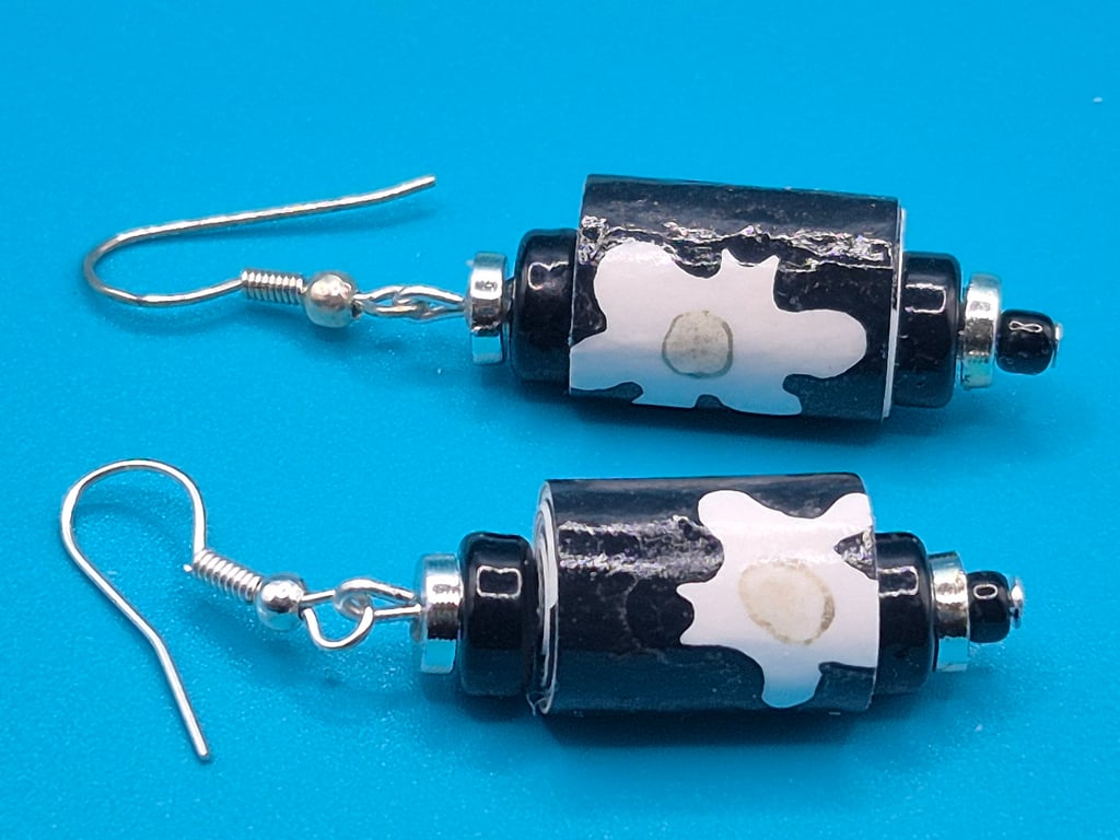 Black paper beaded earrings with white flower patterns