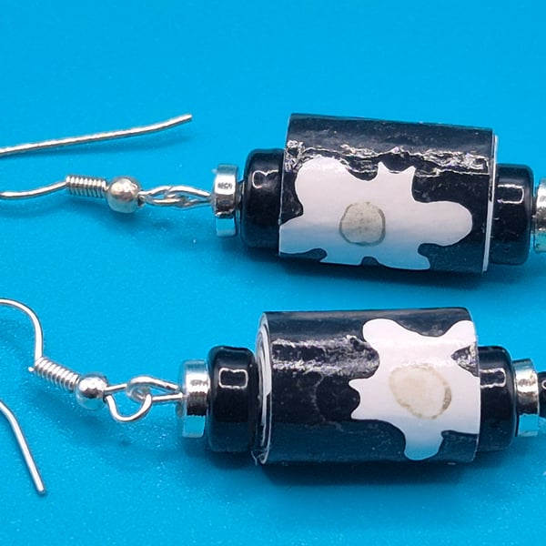 Black paper beaded earrings with white flower patterns
