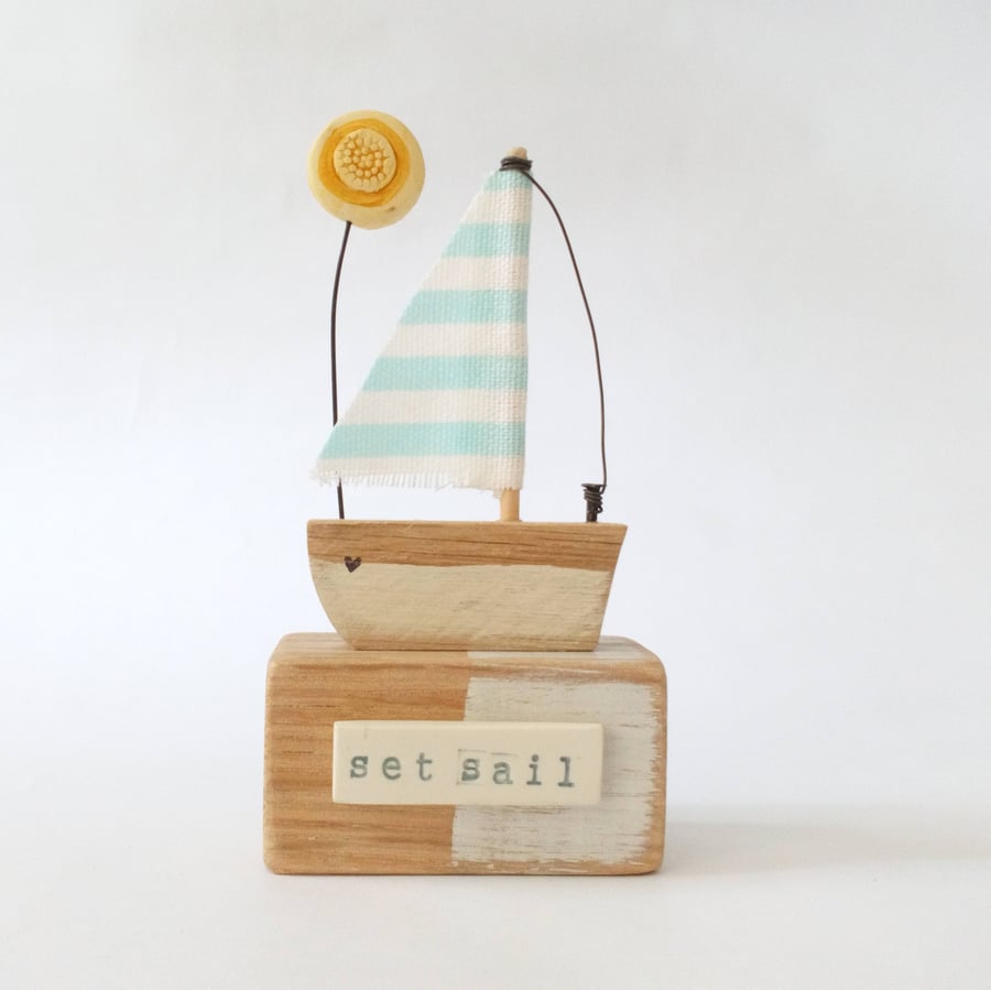 Handmade little wooden sail boat with clay sunshine