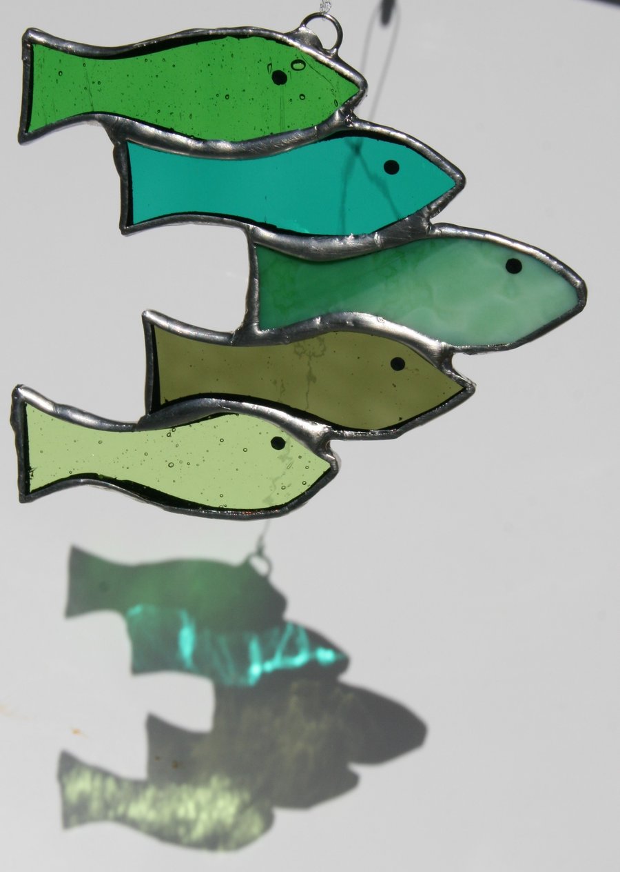 Handmade green shoal of fish using various types of stained glass suncatcher.