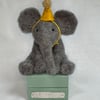 Handcrafted needle felted elephant with removable party hat on a wooden box