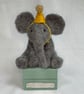 Handcrafted needle felted elephant with removable party hat on a wooden box