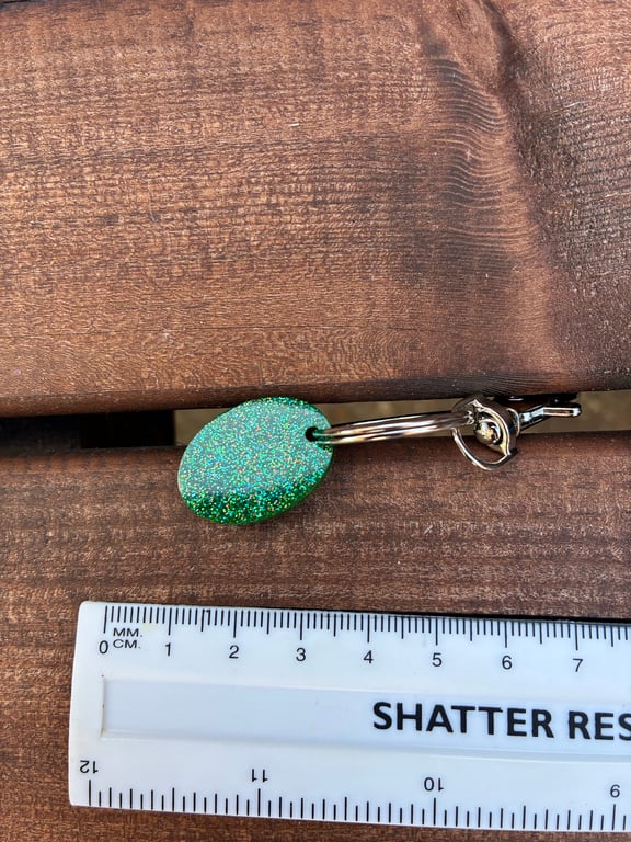 Small green oval epoxy resin keyring with glitter sprinkles