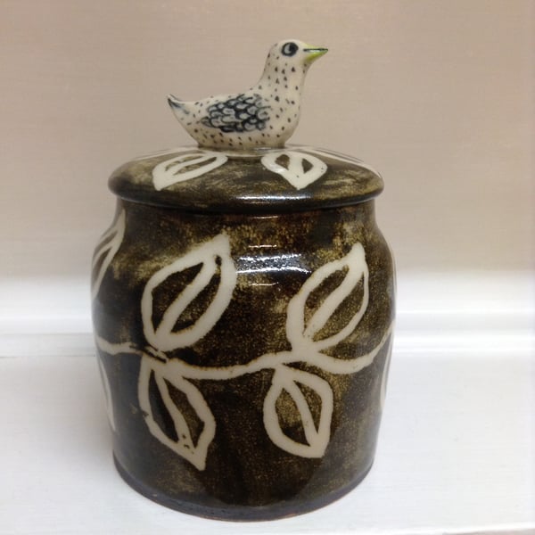 Decorated stoneware lidded jar with bird top
