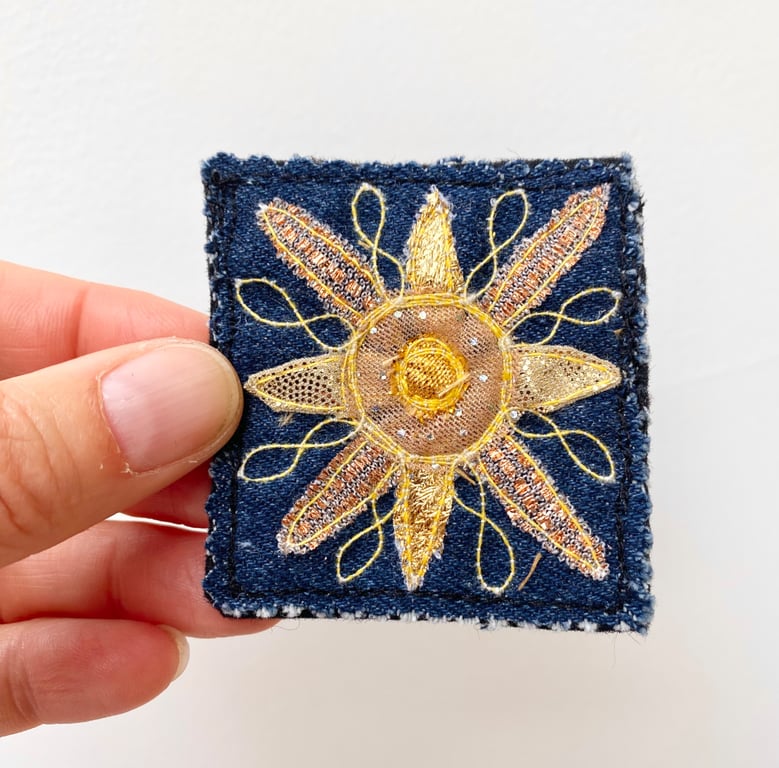 Up-cycled golden sun on denim brooch pin or badge.
