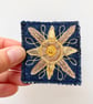 Up-cycled golden sun on denim brooch pin or badge.