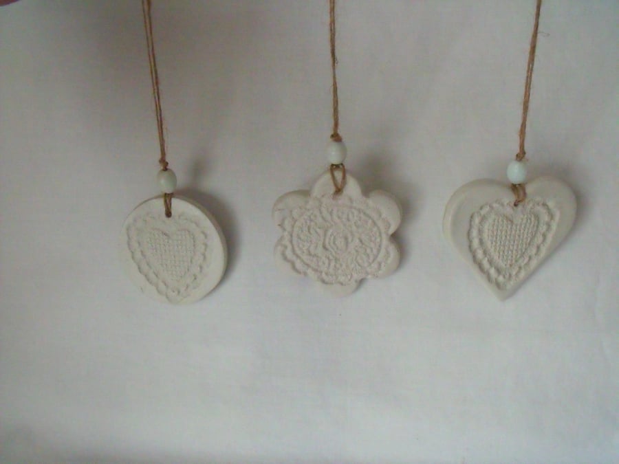 set of three impressed ceramic hanging decorations, unpainted