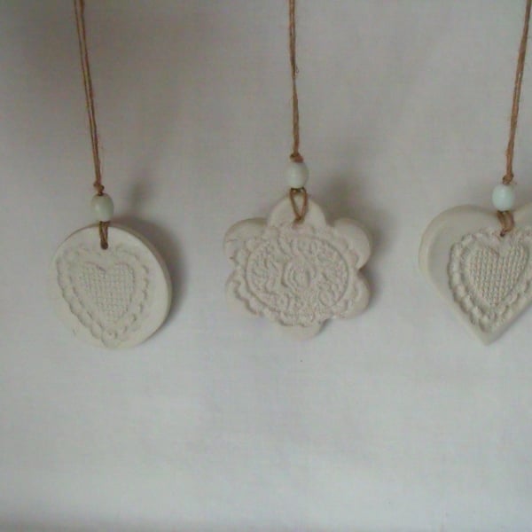 set of three impressed ceramic hanging decorations, unpainted