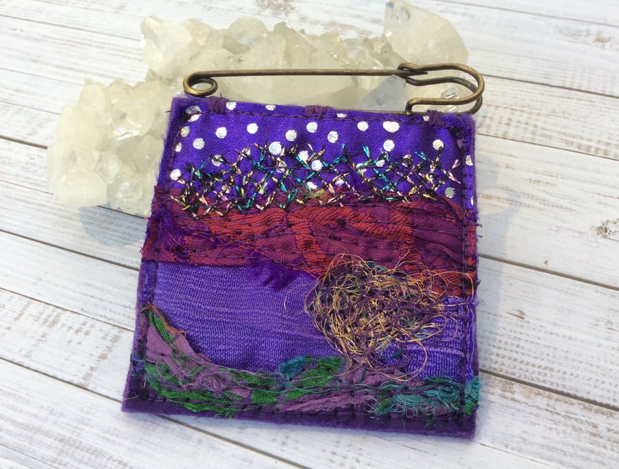 Embroidered up-cycled abstract landscape kilt pin brooch. 