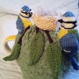 Blue tits on their nest tea cosy