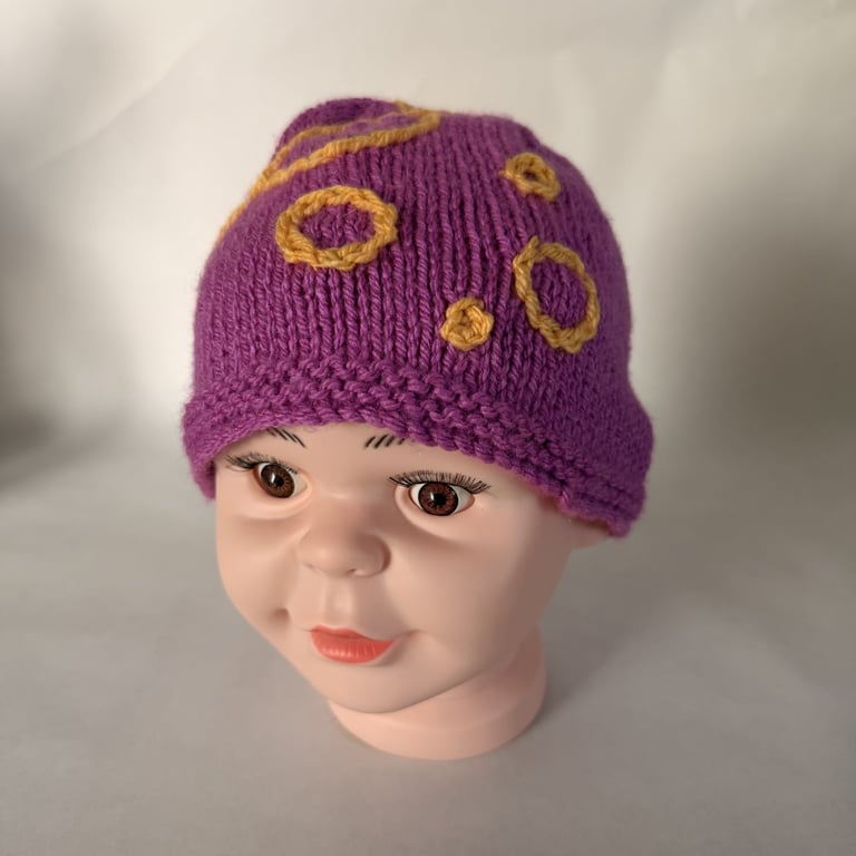 Children's hand knitted winter hat with circle details