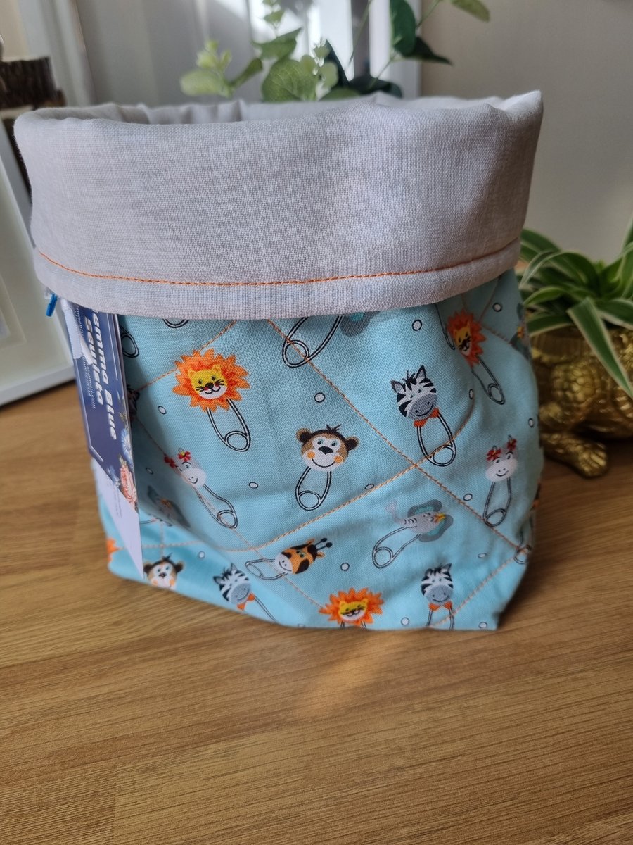 Quilted fabric storage basket, pale turquoise animal head print.