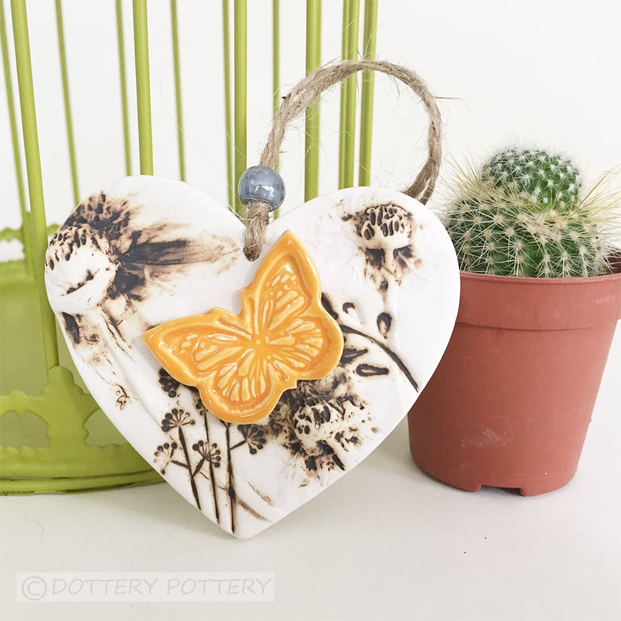 Pottery heart decoration with natural flower design and butterfly