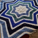 Handmade crochet baby blanket star shaped in stripes of white and shades of blue