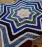 Handmade crochet baby blanket star shaped in stripes of white and shades of blue