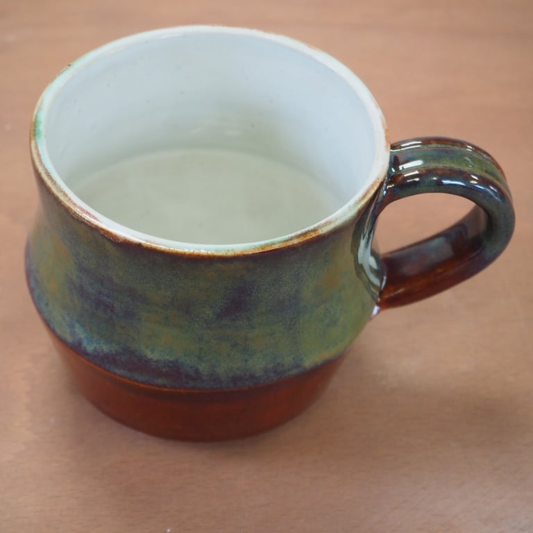  Stoneware pottery mug finished in a red, blue, green, brown combination glaze