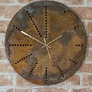 Rusting disc clock using holes as hour markers