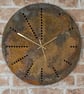 Rusting disc clock using holes as hour markers