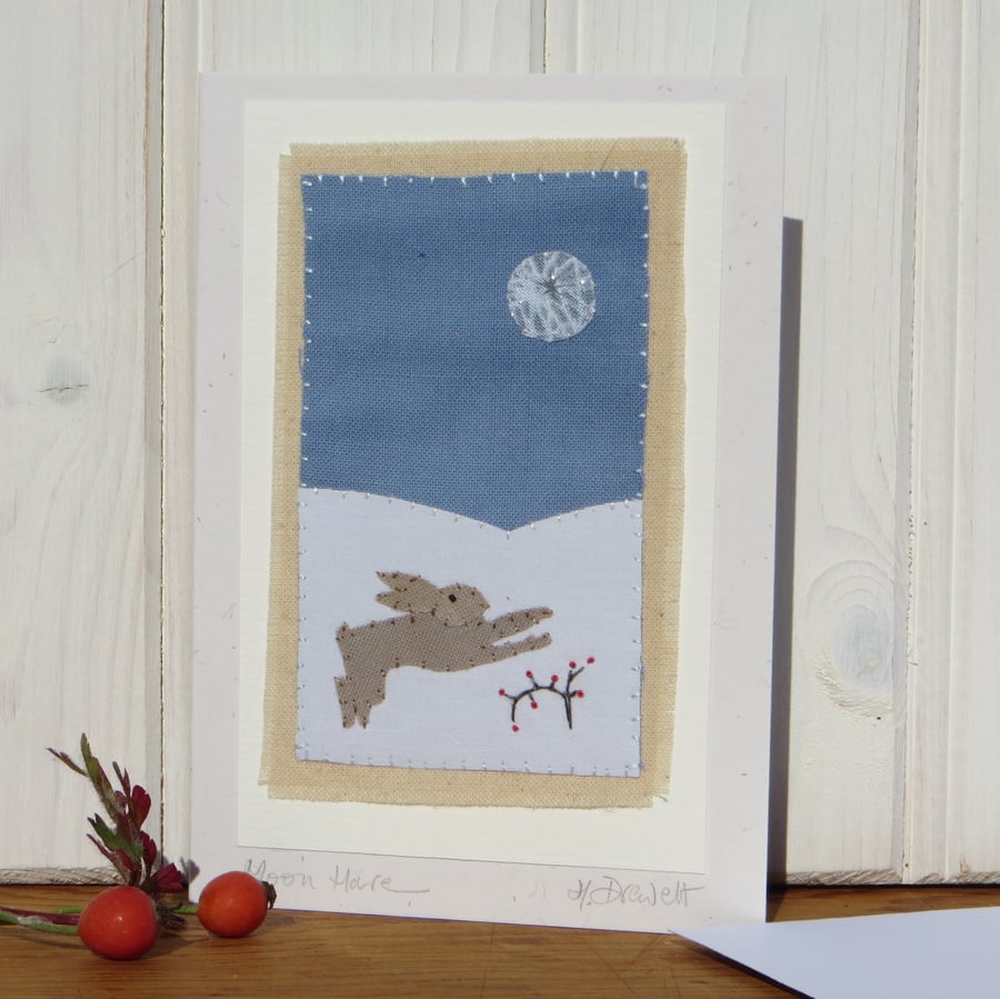 Miniature hand-stitched scene of a leaping hare and moon with berries