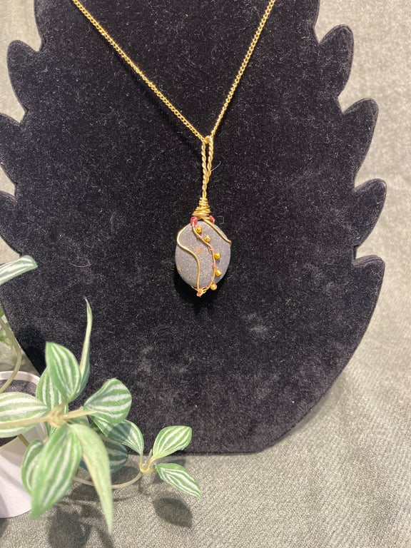 Beautiful wire wrapped pebble pendant on gold coloured chain. 