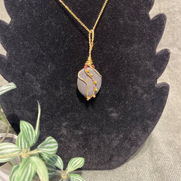Beautiful wire wrapped pebble pendant on gold coloured chain. 