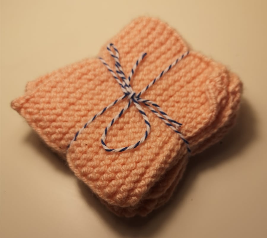 Set of four pink handknitted coasters