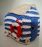 Crocheted beach hut with life ring and real shells