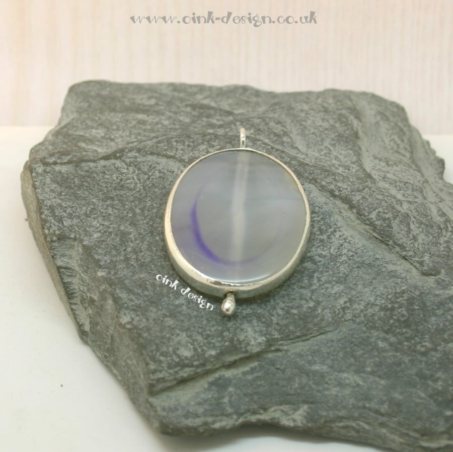 A clear piece of agate with mauve set in sterling silver spectacle setting