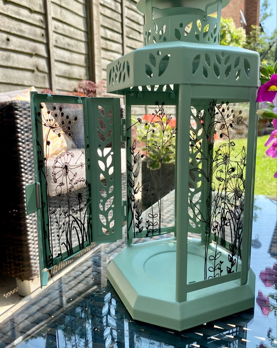 Pale green lantern with enamelled glass panels featuring a floral design