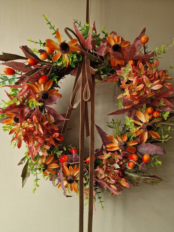 Lush autumn wreath with orange Hydrangea, Orange red berries, maple leaves.