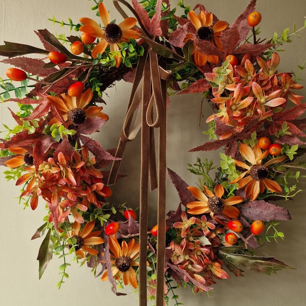 Lush autumn wreath with orange Hydrangea, Orange red berries, maple leaves.