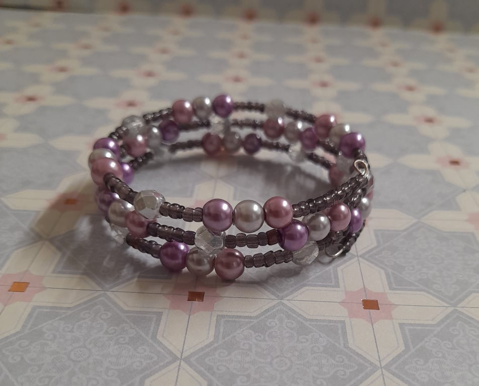 SHADES OF PINKS, PURPLE, GREY AND SILVER MEMORY WIRE BRACELET.
