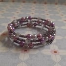 SHADES OF PINKS, PURPLE, GREY AND SILVER MEMORY WIRE BRACELET.